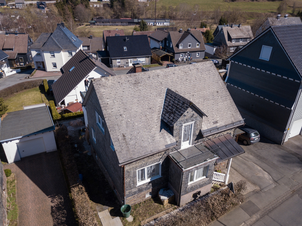 Ein Haus mit Asbestdach vor der Renovierung mit einem leichten Dach